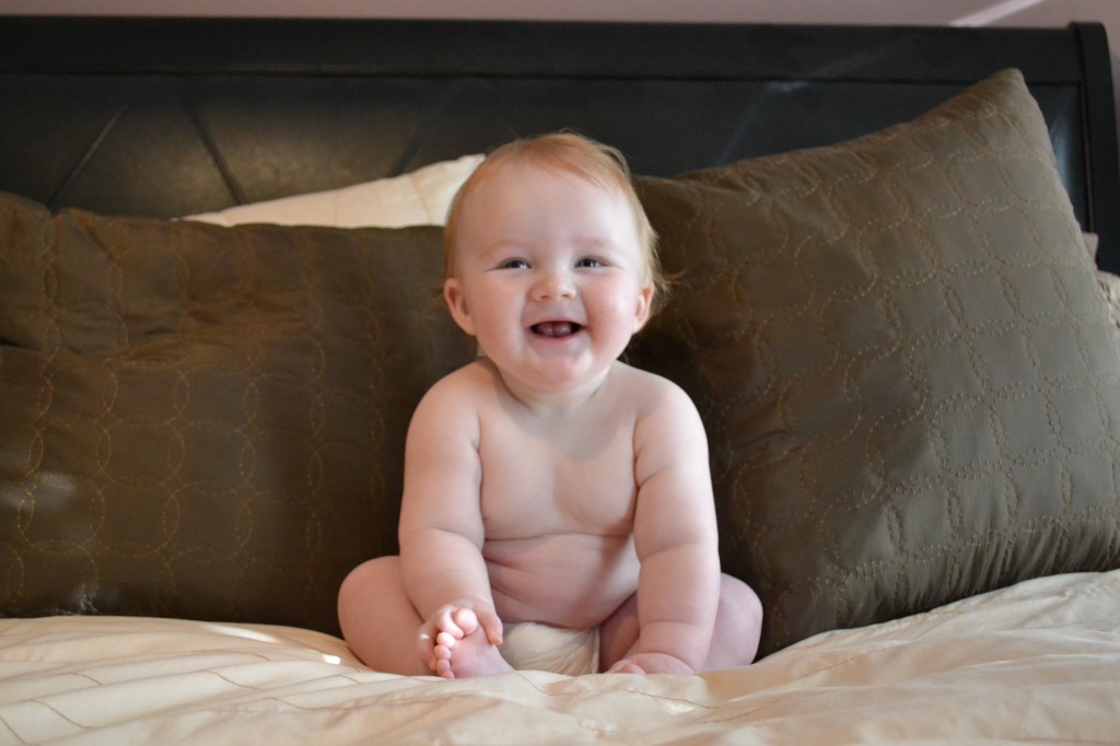 Baby in Diaper Sitting on Bed