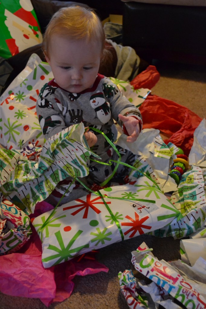 Baby leaning to open presents